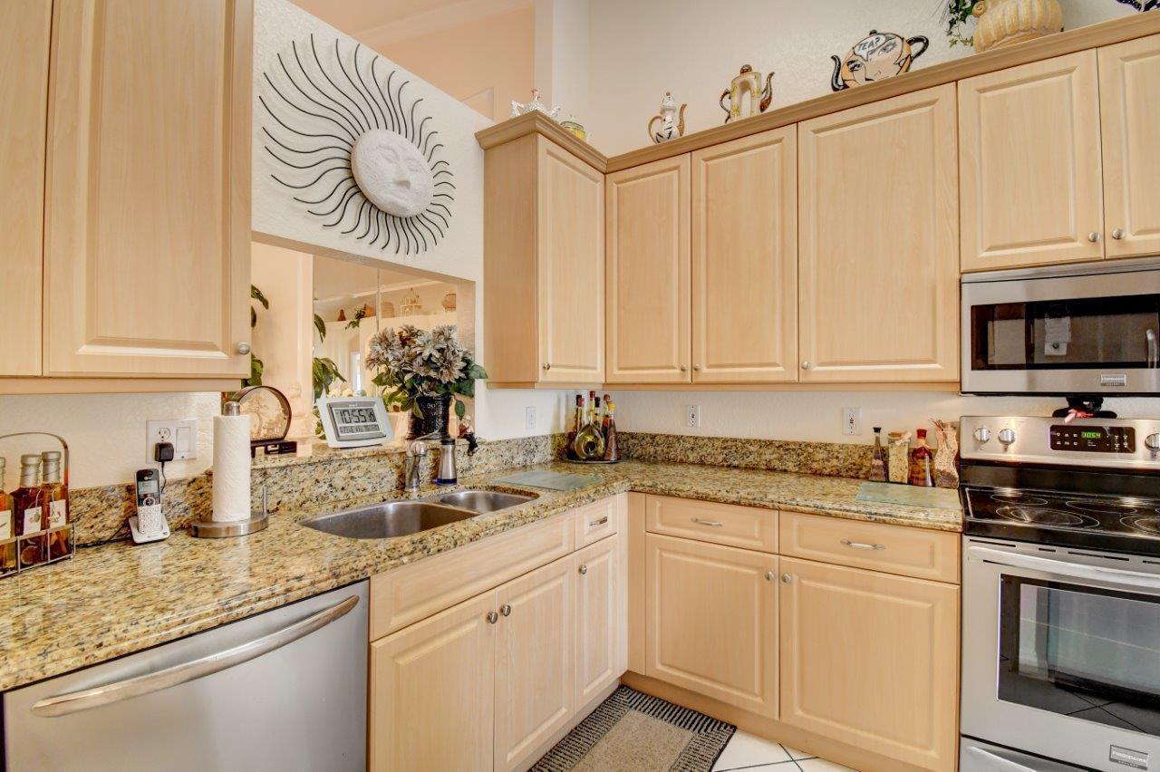 6104 Caladium Road Delray Beach, FL 33484 - Photo 14 of 43 a kitchen with stainless steel appliances granite countertop white cabinets sink and dishwasher
