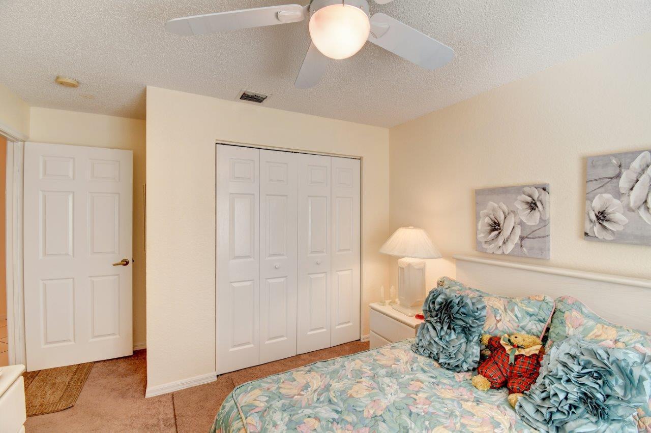 6104 Caladium Road Delray Beach, FL 33484 - Photo 25 of 43 a bedroom with a bed and a chandelier
