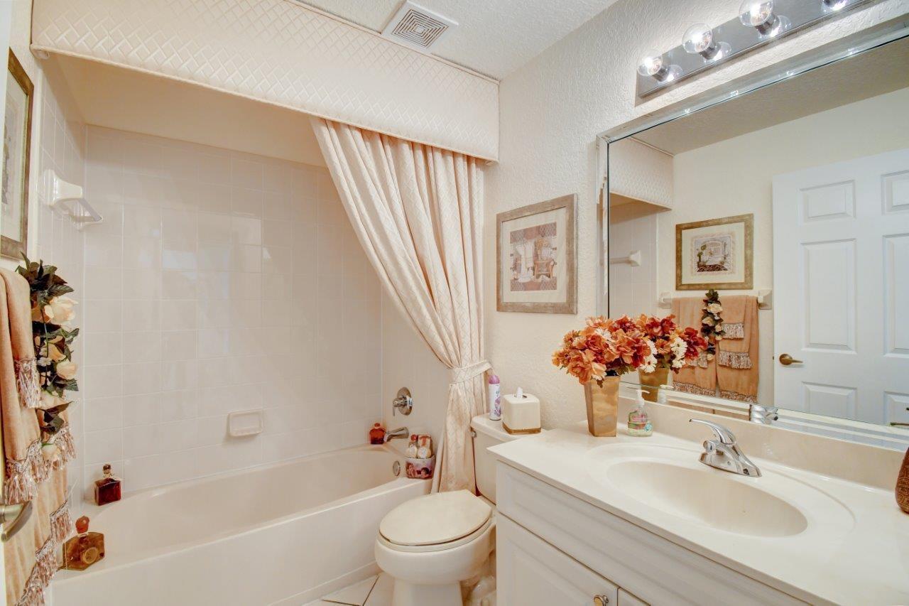6104 Caladium Road Delray Beach, FL 33484 - Photo 27 of 43 a bathroom with a sink a toilet and a mirror