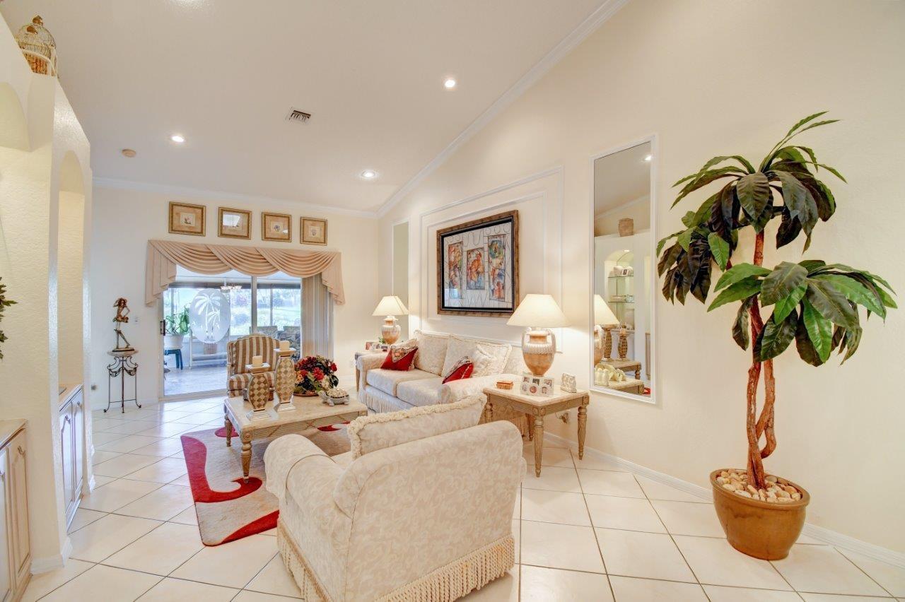 6104 Caladium Road Delray Beach, FL 33484 - Photo 6 of 43 a living room with furniture a chandelier and a potted plant