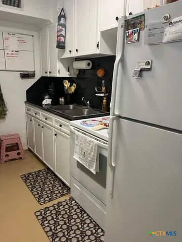 a kitchen with a cabinets and white appliances