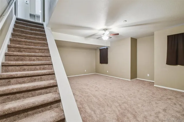 a view of an empty room with a ceiling fan