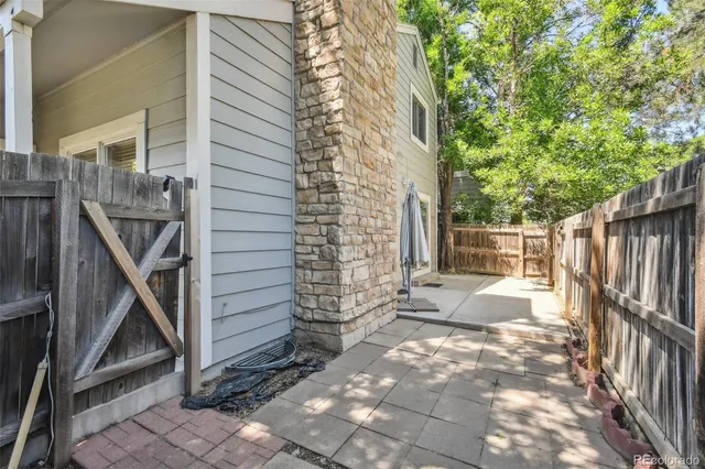 a view of a backyard with potted plants and large tree