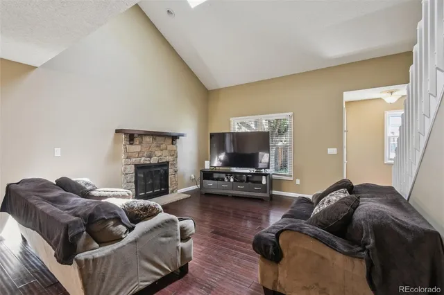 a living room with furniture a flat screen tv and a fireplace