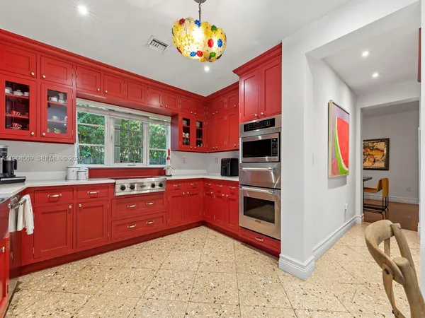 a kitchen with stainless steel appliances kitchen island granite countertop a refrigerator and a stove top oven