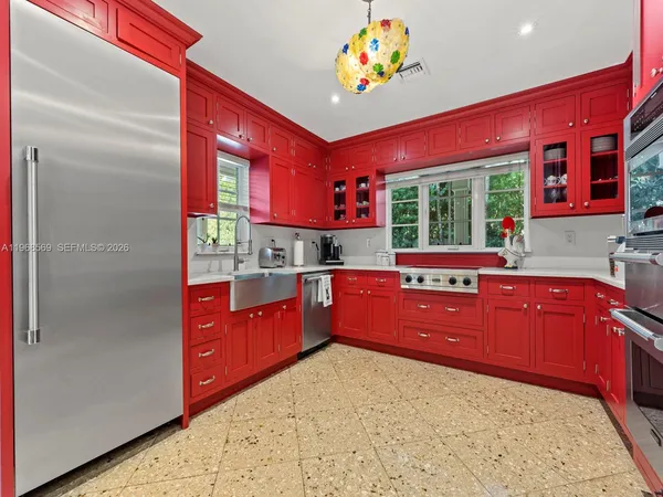 a kitchen with stainless steel appliances kitchen island granite countertop a refrigerator and a sink