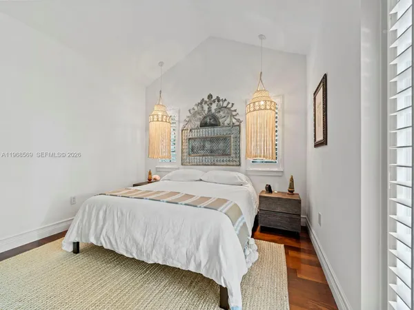 a bedroom with a bed mirror and window