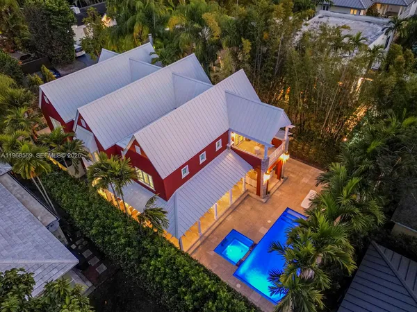 an aerial view of a house with an outdoor space and seating area