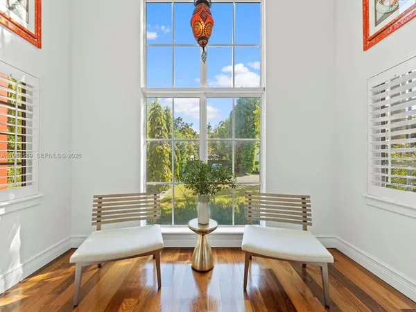a view of a dining room with furniture a potted plant and wooden floor