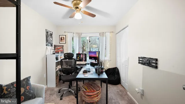 a view of a workspace with furniture and a window