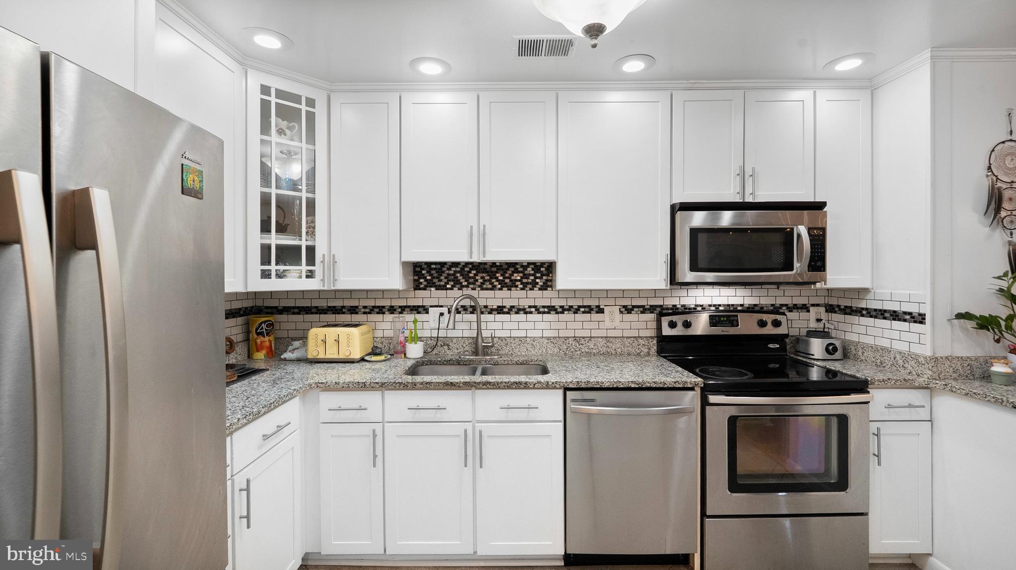 12862 Sage Terrace Germantown, MD 20874 - Photo 23 of 25 a kitchen with stainless steel appliances granite countertop a stove a sink and a microwave