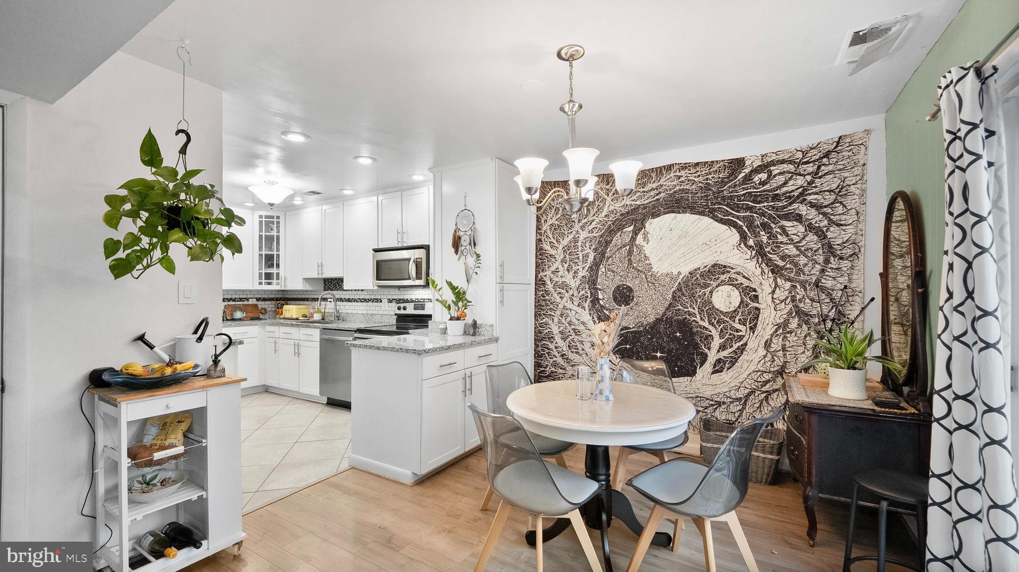 12862 Sage Terrace Germantown, MD 20874 - Photo 4 of 25 a kitchen with stainless steel appliances kitchen island a table and chairs in it