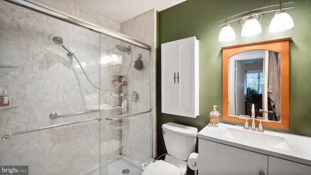 a bathroom with a granite countertop sink toilet and shower