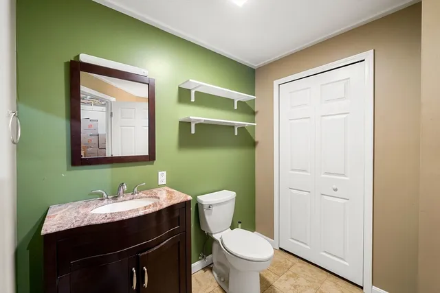 a bathroom with a granite countertop toilet sink and mirror