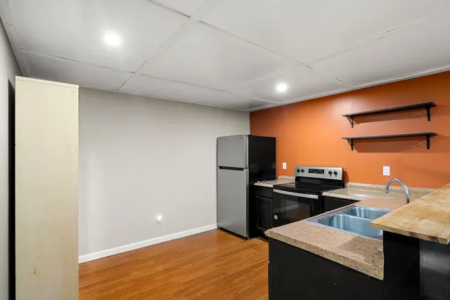 a kitchen with stainless steel appliances granite countertop a sink refrigerator and stove