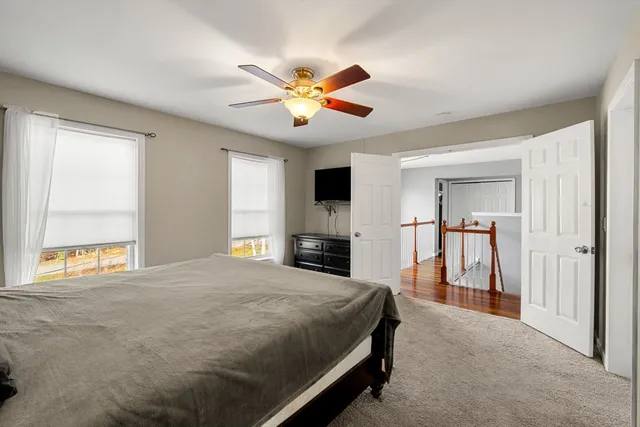 a bedroom with a large bed and a ceiling fan