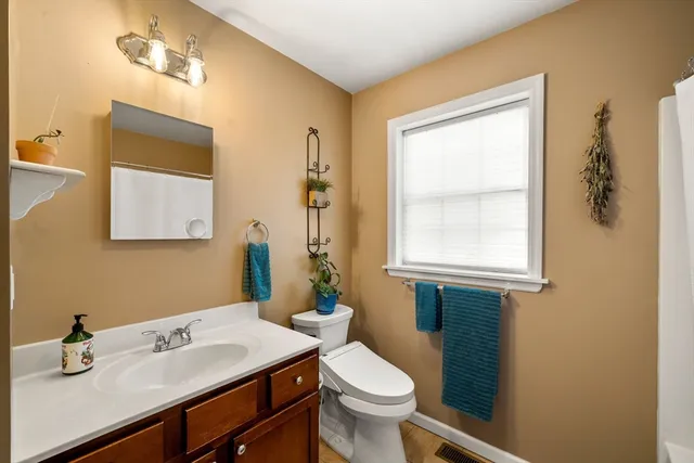 a bathroom with a sink a toilet and mirror