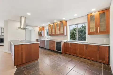 a kitchen with stainless steel appliances kitchen island granite countertop a refrigerator and a sink