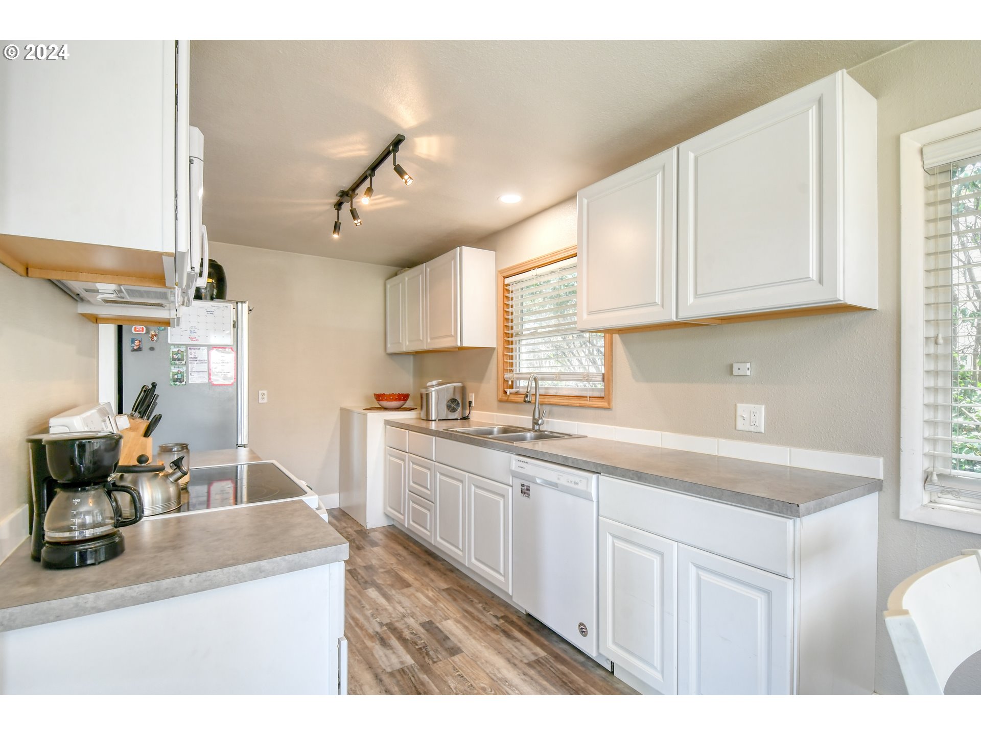 824 Southwest 8th Street Pendleton, OR 97801 - Photo 8 of 28 a kitchen with stainless steel appliances granite countertop a sink dishwasher a stove and white cabinets with wooden floor
