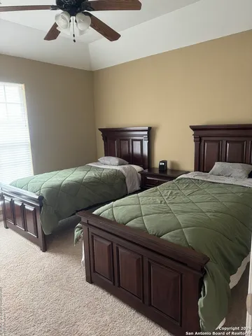 a bedroom with two beds and painting on the wall