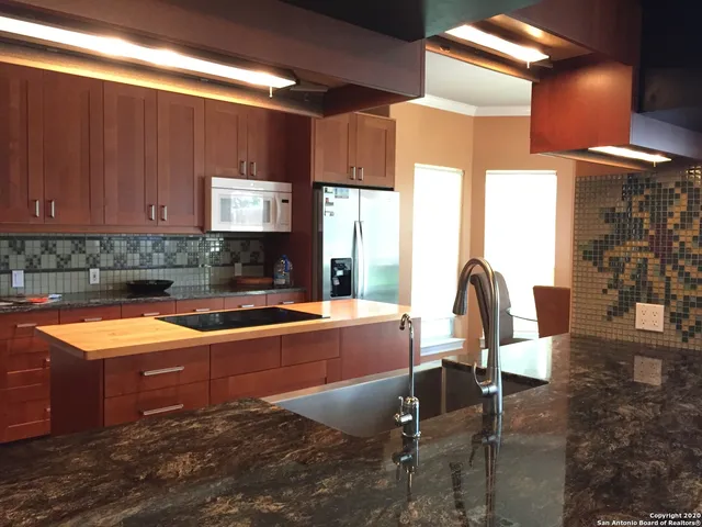 a kitchen with stainless steel appliances granite countertop sink stove and cabinets