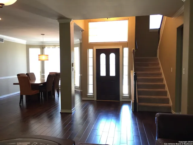 a view of a hallway with dining room and wooden floor