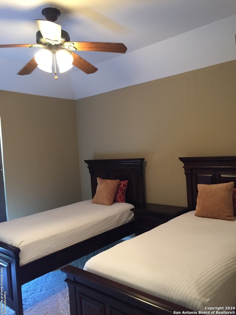 3 Lindquist San Antonio, TX 78248 - Photo 30 of 35 a bedroom with a bed and a chandelier