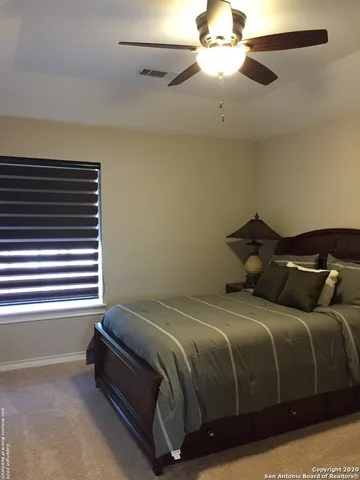 a bedroom with a bed and a chandelier fan