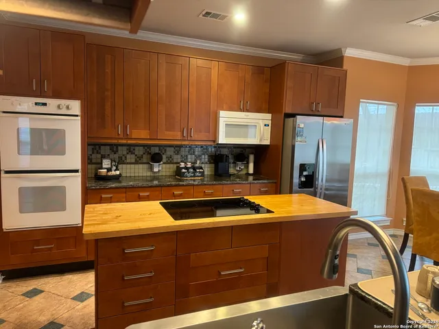 a kitchen with stainless steel appliances granite countertop a refrigerator and a stove top oven