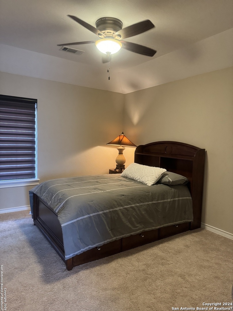 3 Lindquist San Antonio, TX 78248 - Photo 10 of 35 a bedroom with a bed and a chandelier