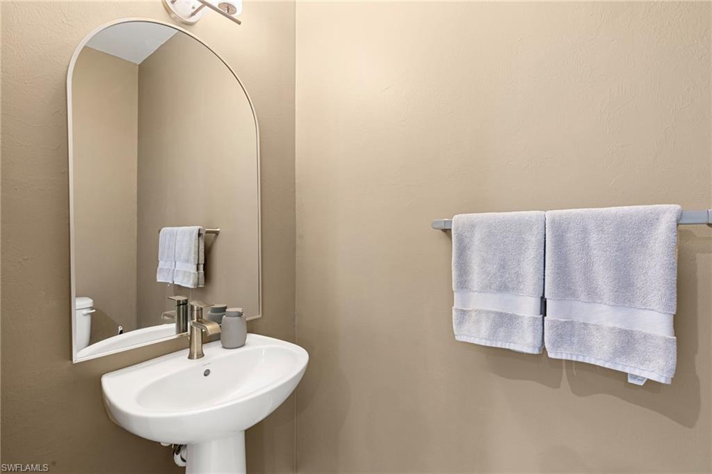 7622 Rockefeller Drive Naples, FL 34119 - Photo 13 of 35 a bathroom with a sink and mirror