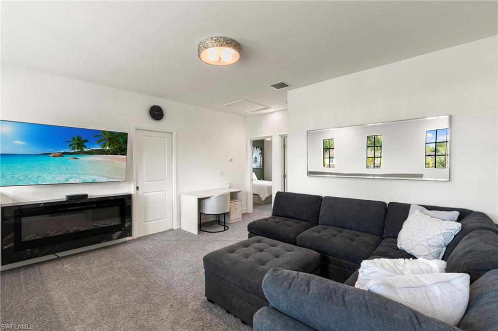 7622 Rockefeller Drive Naples, FL 34119 - Photo 15 of 35 a living room with furniture and a fireplace