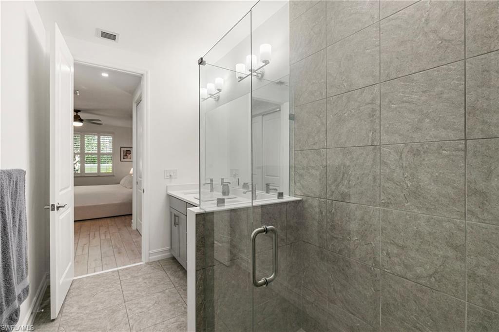 7622 Rockefeller Drive Naples, FL 34119 - Photo 21 of 35 a bathroom with a double vanity sink a toilet and shower
