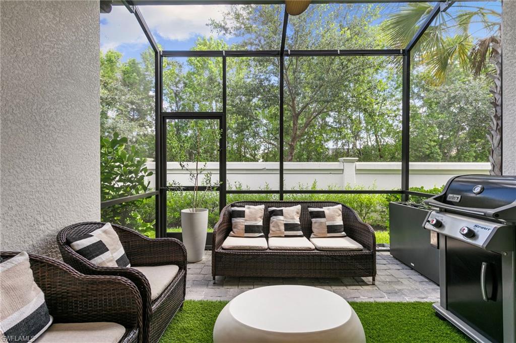 7622 Rockefeller Drive Naples, FL 34119 - Photo 28 of 35 a living room with furniture and a floor to ceiling window