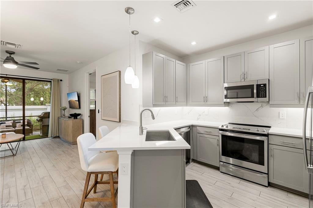 7622 Rockefeller Drive Naples, FL 34119 - Photo 3 of 35 a kitchen with a sink stove and microwave