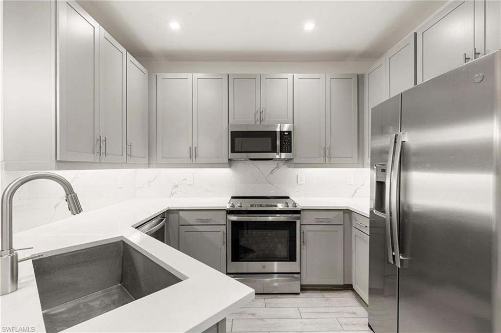 7622 Rockefeller Drive Naples, FL 34119 - Photo 5 of 35 a kitchen with a sink cabinets and stainless steel appliances