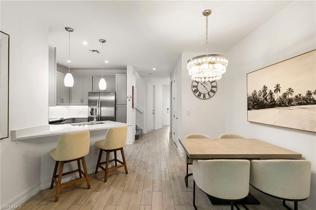 7622 Rockefeller Drive Naples, FL 34119 - Photo 6 of 35 a view of a dining room with furniture and wooden floor
