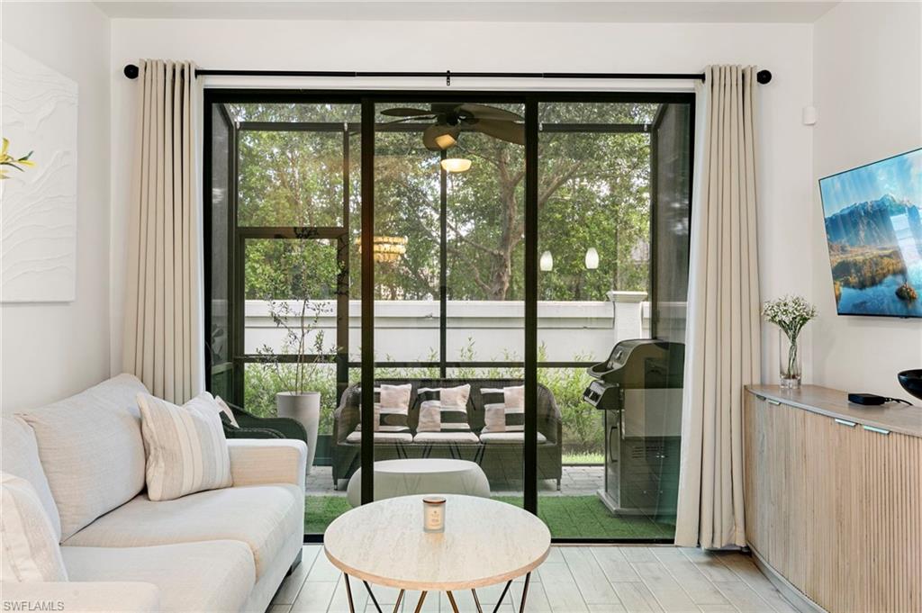 7622 Rockefeller Drive Naples, FL 34119 - Photo 9 of 35 a living room with furniture and a floor to ceiling window