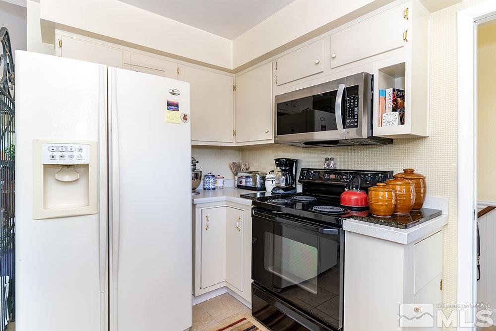 11325 Maverick Lane Reno, NV 89511 - Photo 5 of 20 a kitchen with stainless steel appliances granite countertop a refrigerator stove microwave and sink