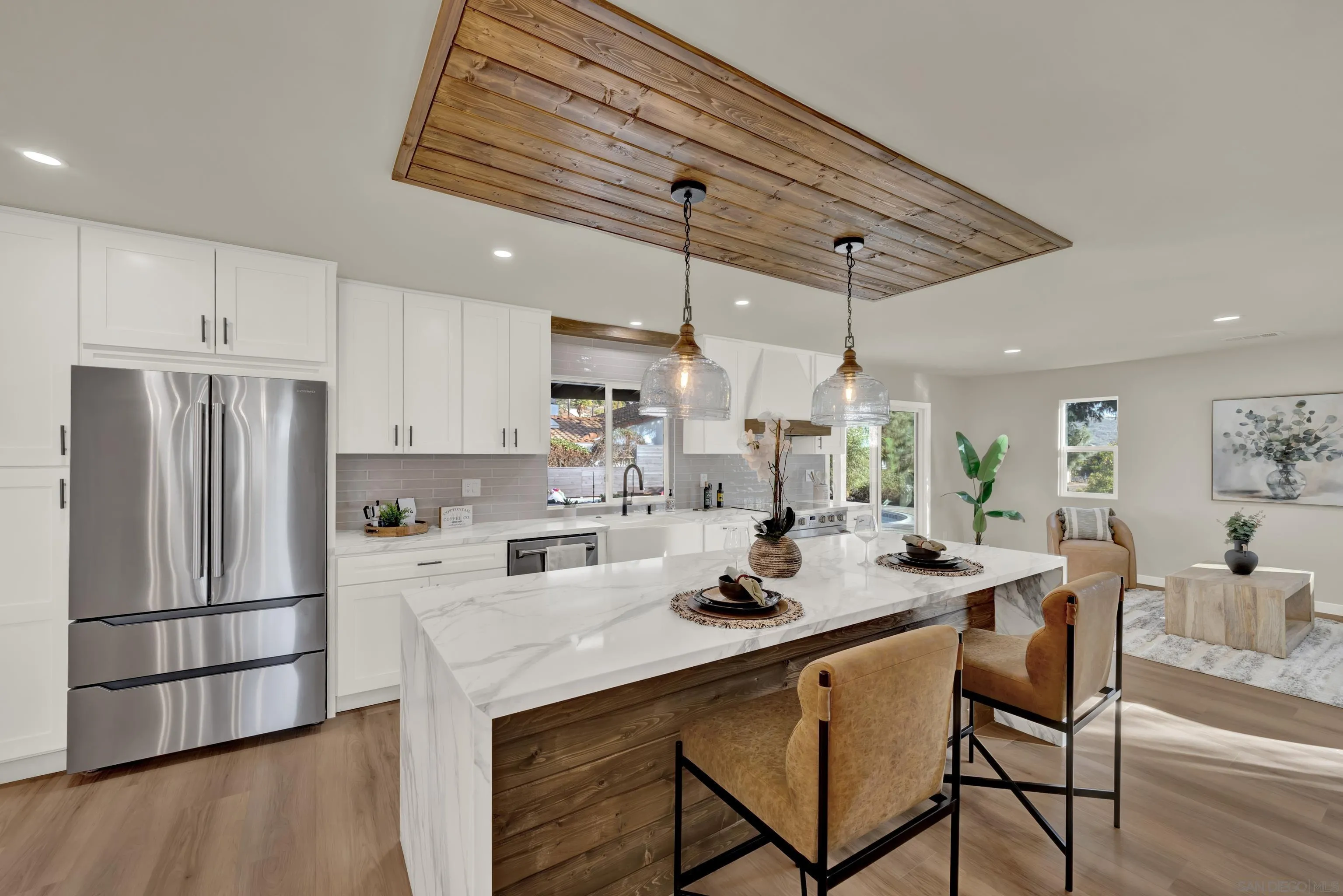 14407 Mountain Road Poway, CA 92064 - Photo 22 of 75 a kitchen with stainless steel appliances kitchen island granite countertop a table chairs in it and wooden floors