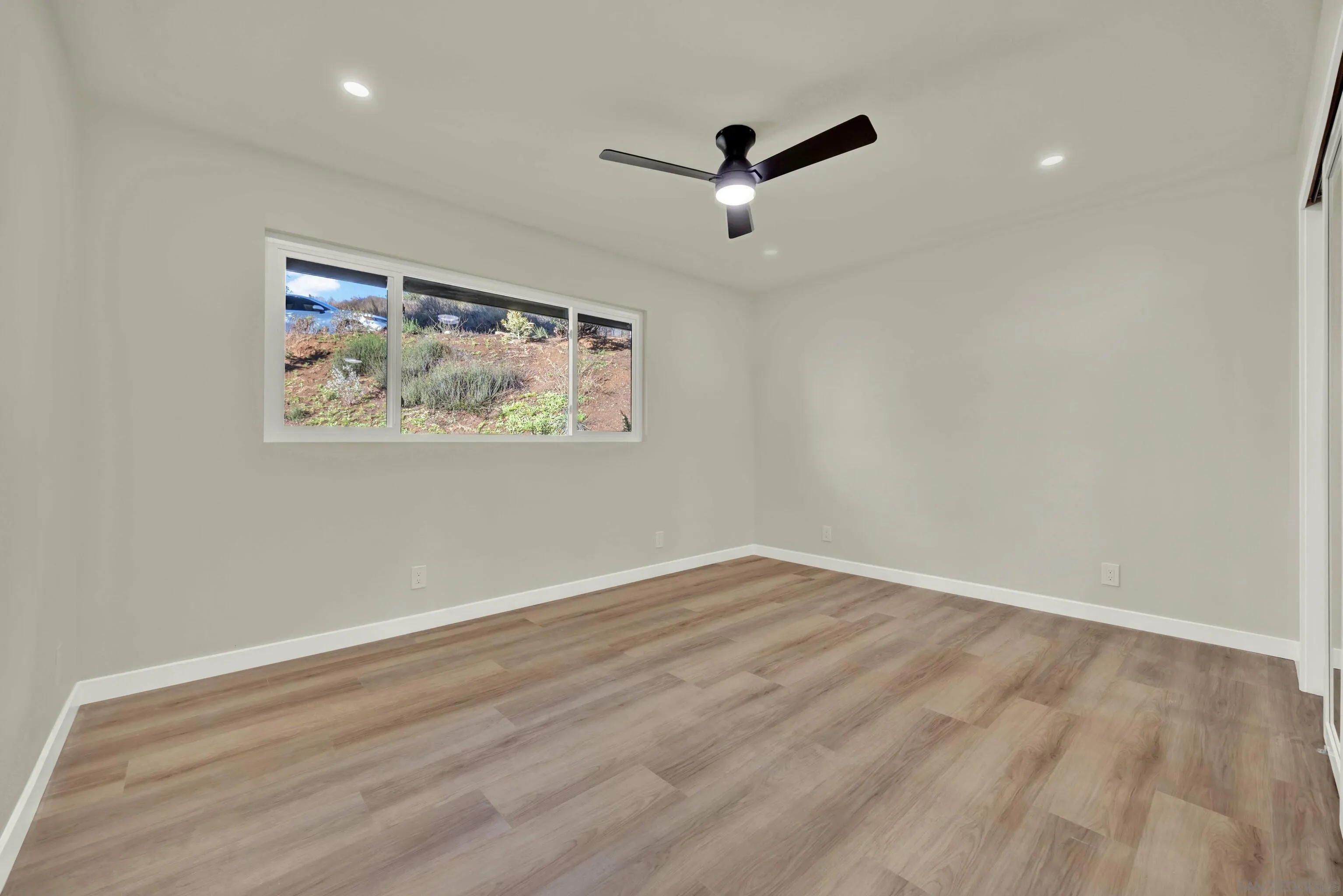 14407 Mountain Road Poway, CA 92064 - Photo 52 of 75 an empty room with wooden floor and windows