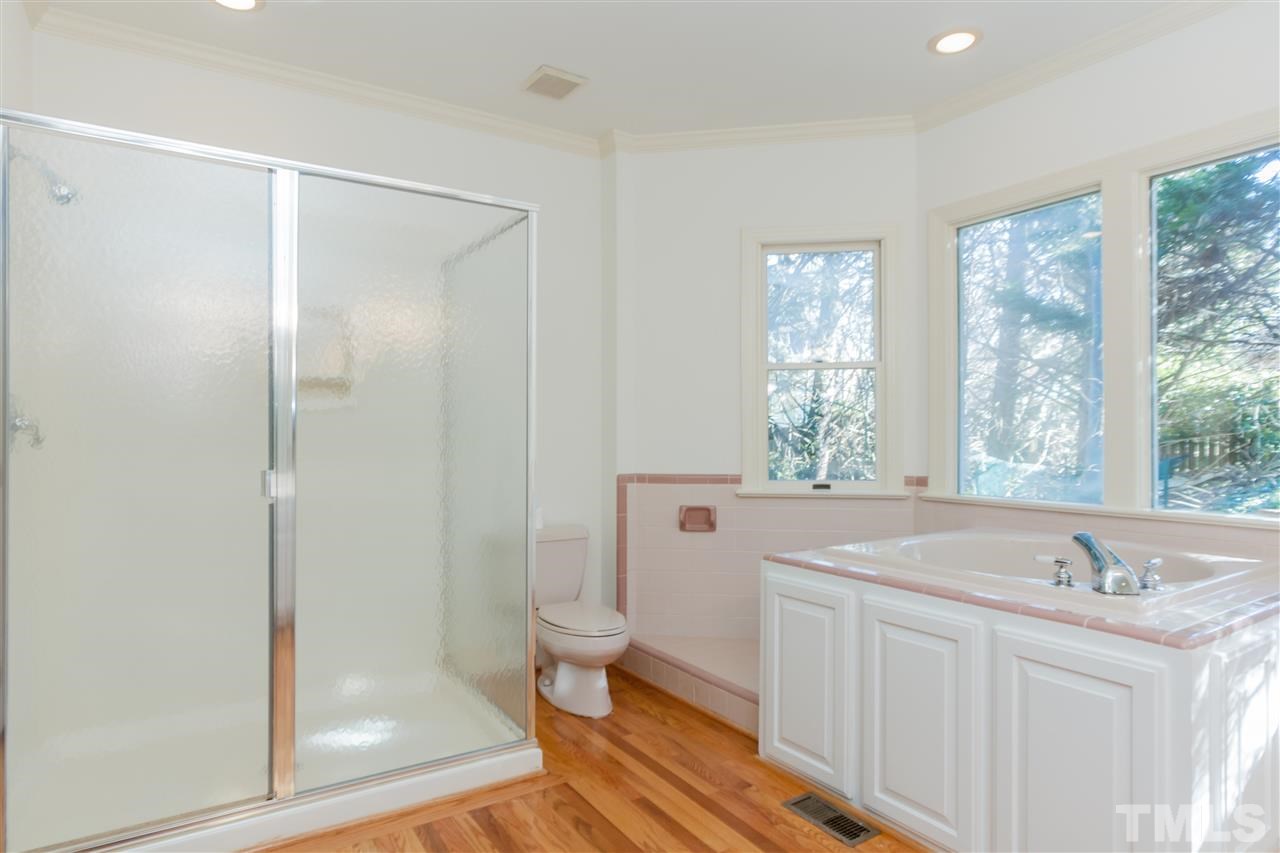 2008 Tradd Court Raleigh, NC 27607 - Photo 13 of 25 a spacious bathroom with a granite countertop sink a toilet a mirror and window