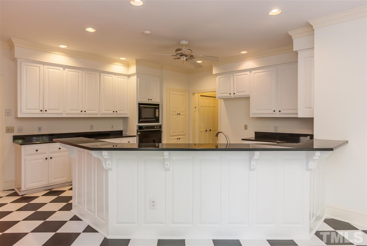 2008 Tradd Court Raleigh, NC 27607 - Photo 9 of 25 a large kitchen with stainless steel appliances a large counter top a stove a sink and a refrigerator