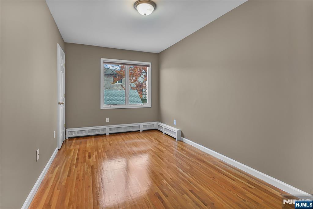 75 West Columbia Avenue, Unit 2 Palisades Park, NJ 07650 - Photo 14 of 27 a view of an empty room with wooden floor and a window