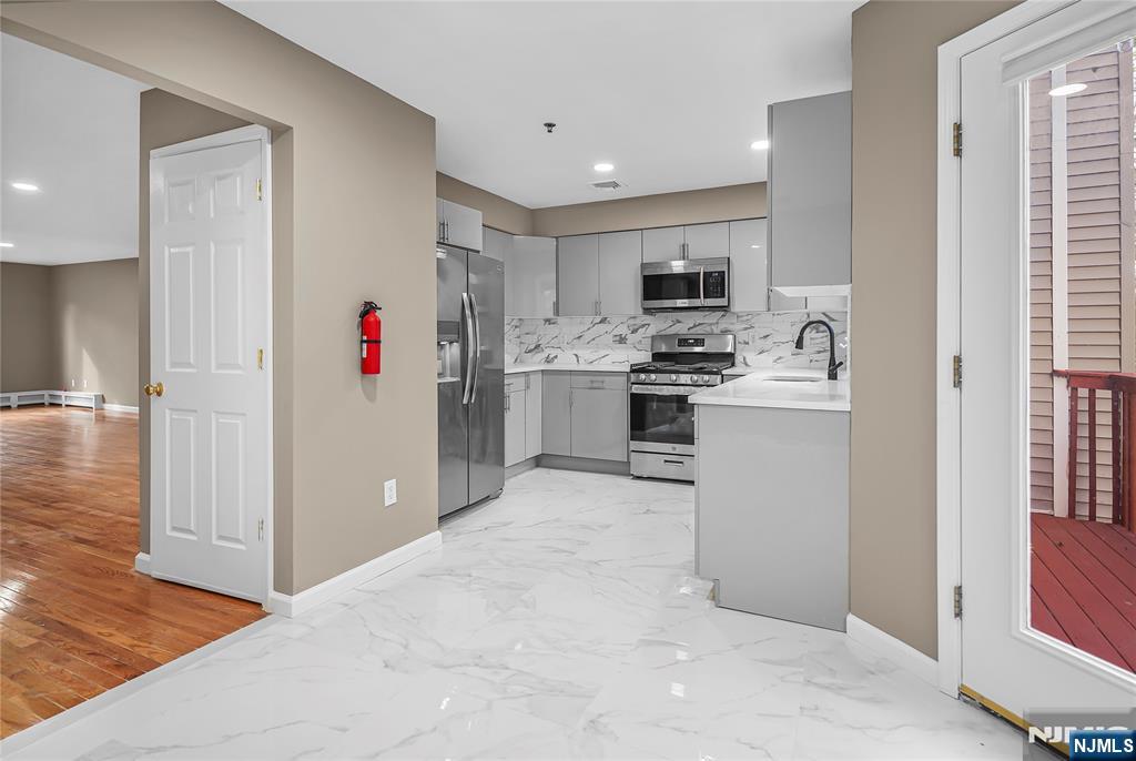 75 West Columbia Avenue, Unit 2 Palisades Park, NJ 07650 - Photo 4 of 27 a kitchen with cabinets and wooden floor