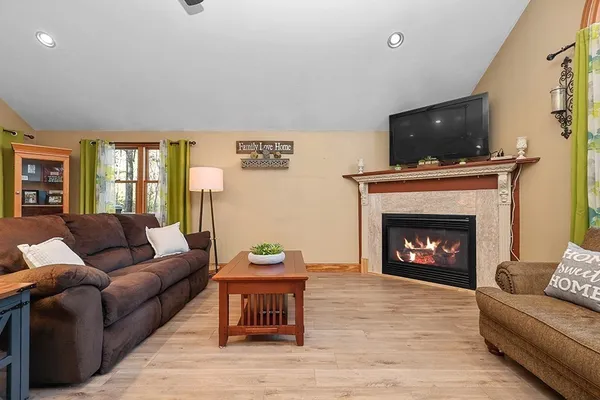 a living room with furniture a flat screen tv and a fireplace