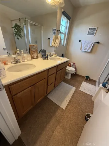 a bathroom with a double vanity sink mirror and toilet