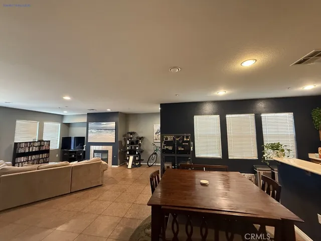 a kitchen with stainless steel appliances granite countertop a stove a refrigerator a sink a dining table and chairs