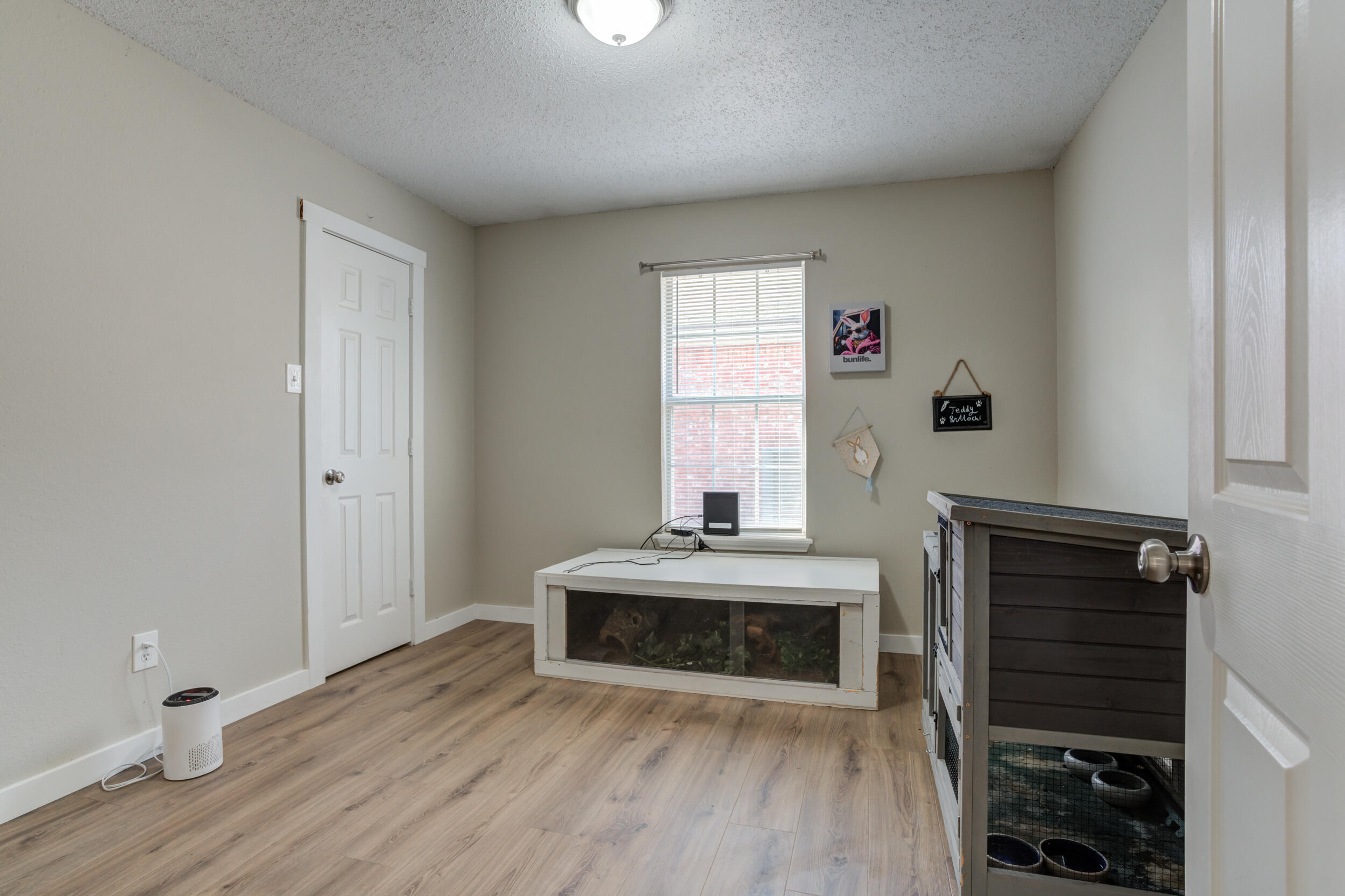 8406 Canton Avenue Lubbock, TX 79423 - Photo 16 of 25 a view of an empty room with wooden floor and a window