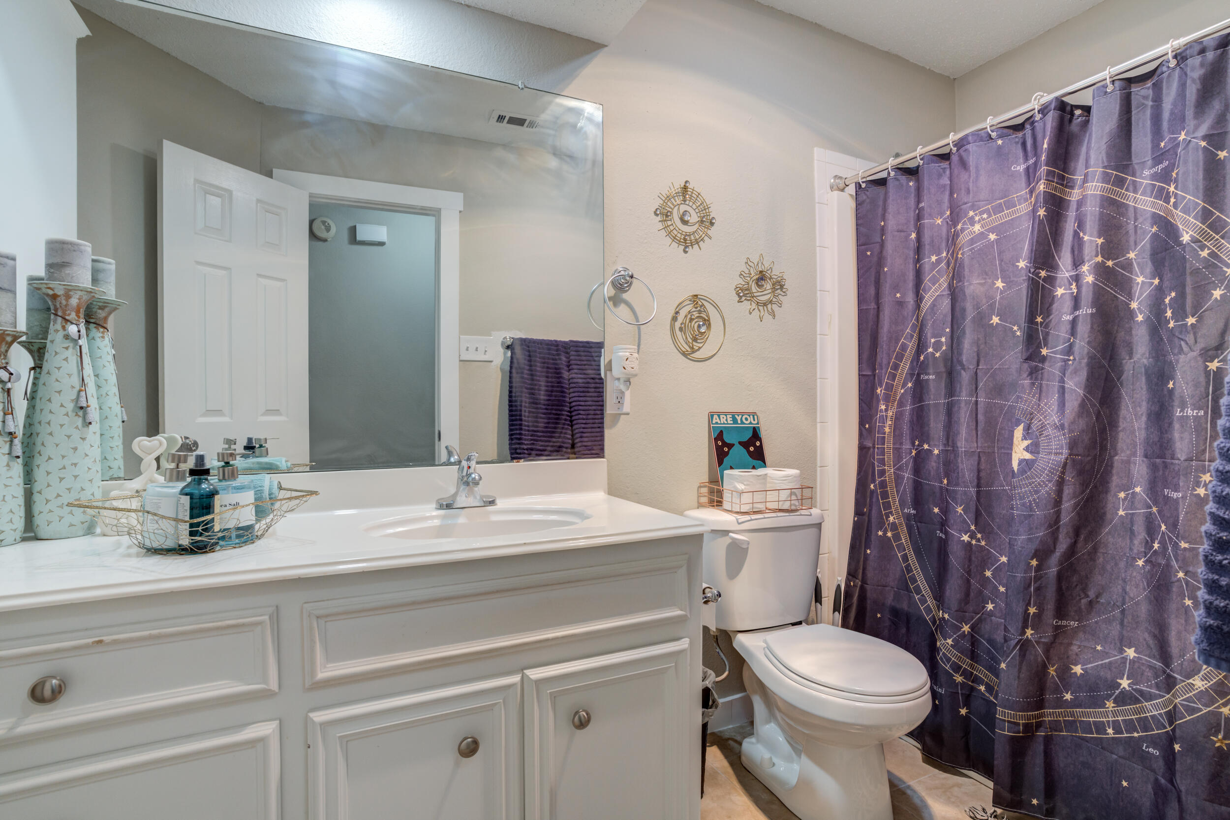 8406 Canton Avenue Lubbock, TX 79423 - Photo 17 of 25 a bathroom with a granite countertop toilet sink and mirror